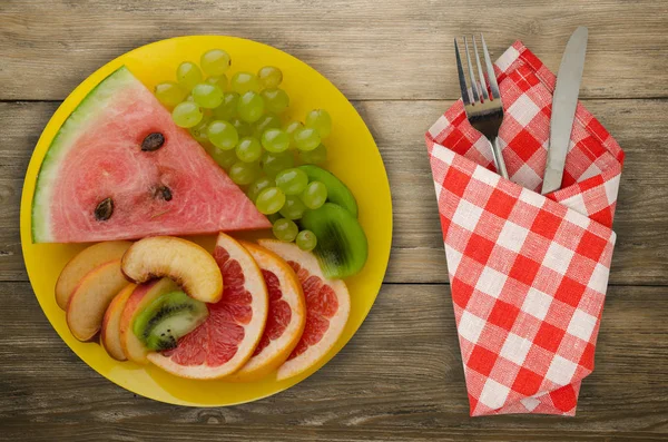 meyve bir ahşap arka plan üzerine dilimlenmiş. meyve bir tabağa dilimlenmiş