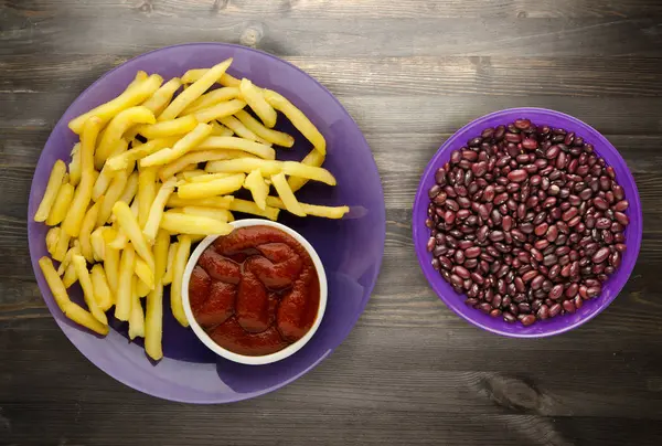 ahşap bir zemin üzerine ketçap ile kızarmış patates. patates kızartması bir plaka üzerinde