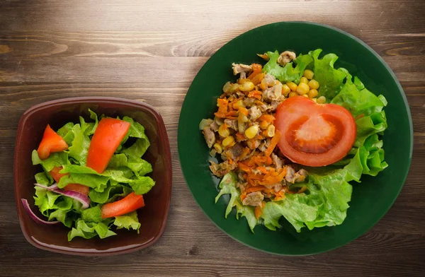 tavuk mideleri havuç ve Mısır ve bir tabak salataya salata. ahşap arka plan üzerinde Sebzeli tavuk salatası