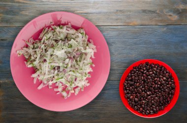 salata daikon, soğan ve bir ahşap zemin üzerine dereotu. bir tabak salata