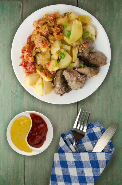 Pedaços de fígado frito com molho de tomate, cebolas e pepinos em conserva  delicioso prato saudável