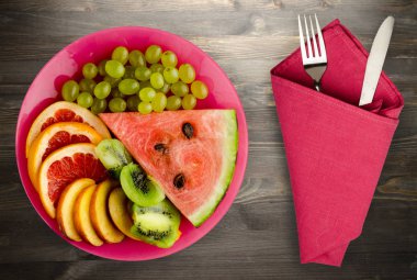 meyve bir ahşap arka plan üzerine dilimlenmiş. meyve bir tabağa dilimlenmiş