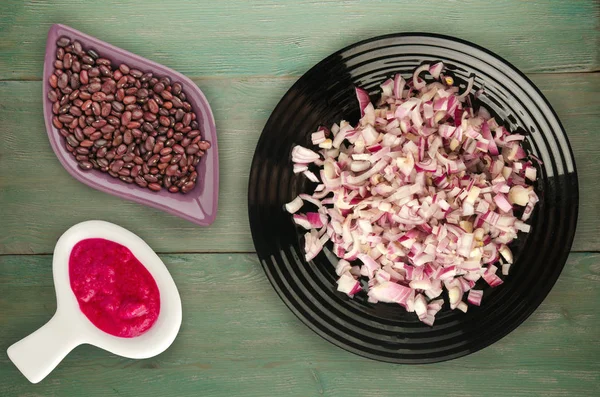 ahşap arka plan üzerinde kırmızı soğan. bir plaka üzerinde doğranmış kırmızı soğan