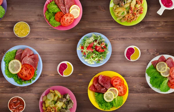 et yemekleri bir plaka üzerinde. bir tabak salata. masaya yiyecek bolluğu. Gıda üstten görünüm