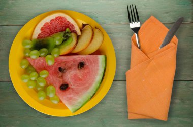 meyve bir ahşap arka plan üzerine dilimlenmiş. meyve bir tabağa dilimlenmiş