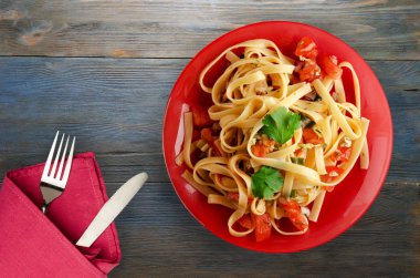 bir tabak spagetti. Spagetti domates, soğan, lahana ahşap arka plan üzerinde