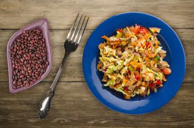 salata tavuk mideleri sebzeler (havuç, soğan, biber, lahana, domates, brokoli) ile. ahşap arka plan üzerinde bir tabakta Tavuk salatası