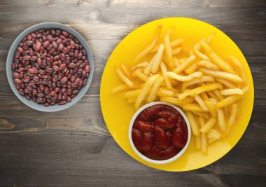 ahşap bir zemin üzerine ketçap ile kızarmış patates. patates kızartması bir plaka üzerinde