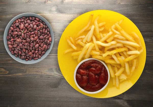 ahşap bir zemin üzerine ketçap ile kızarmış patates. patates kızartması bir plaka üzerinde