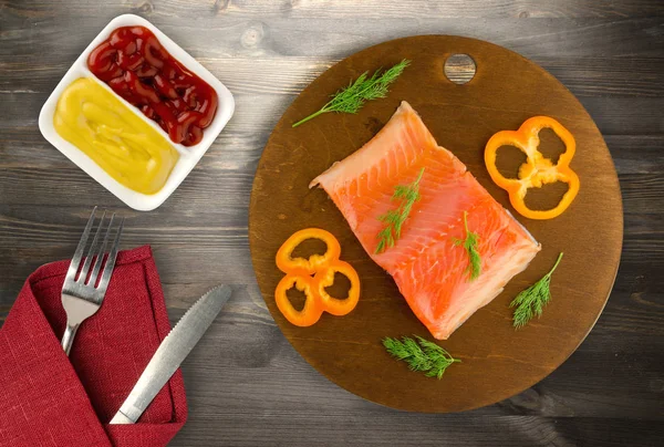 red fish trout fillets on a plate. fish trout on a wooden background. trout with dill, lemon and pepper