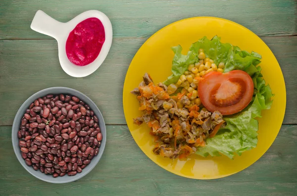 tavuk mideleri havuç ve Mısır ve bir tabak salataya salata. ahşap arka plan üzerinde Sebzeli tavuk salatası