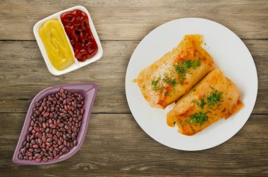 lahana bir tabak içinde alır. lahana bir ahşap arka plan üzerinde rulo. et lahana Üstten Görünüm.