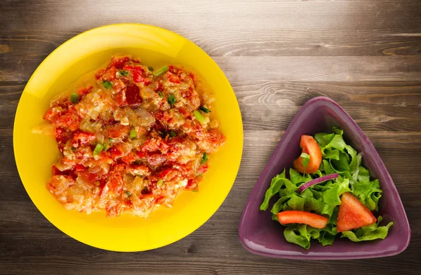 Haşlanmış domates soğan bir plaka üzerinde bir ahşap arka plan ile. haşlanmış domates soğan en iyi manzaralı. Vejetaryen Gıda