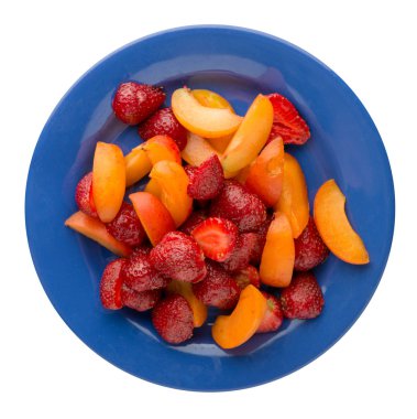  Beyaz arka plan üzerinde izole bir plaka üzerinde dilimlenmiş çilek ve kayısı. dilimlenmiş çilek ve kayısı bir plaka üstten görünüm