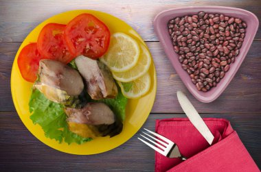 bir plaka üzerinde füme uskumru. uskumru limon ve ahşap arka plan üzerinde domates