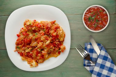 Haşlanmış domates soğan bir plaka üzerinde bir ahşap arka plan ile. haşlanmış domates soğan en iyi manzaralı. Vejetaryen Gıda