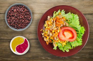 tavuk mideleri havuç ve Mısır ve bir tabak salataya salata. ahşap arka plan üzerinde Sebzeli tavuk salatası