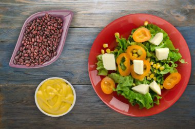  salata, peynir, salata, Mısır, biber ahşap arka plan üzerinde. Vejetaryen salata bir plaka üzerinde. Vejetaryen salata Üstten Görünüm