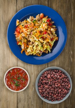 salata tavuk mideleri sebzeler (havuç, soğan, biber, lahana, domates, brokoli) ile. ahşap arka plan üzerinde bir tabakta Tavuk salatası