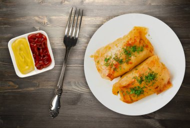 lahana bir tabak içinde alır. lahana bir ahşap arka plan üzerinde rulo. et lahana Üstten Görünüm.