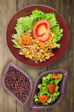 tavuk mideleri havuç ve Mısır ve bir tabak salataya salata. ahşap arka plan üzerinde Sebzeli tavuk salatası