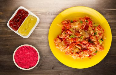 Haşlanmış domates soğan bir plaka üzerinde bir ahşap arka plan ile. haşlanmış domates soğan en iyi manzaralı. Vejetaryen Gıda