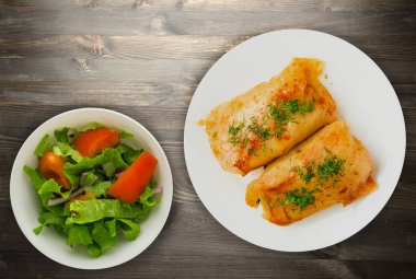 lahana bir tabak içinde alır. lahana bir ahşap arka plan üzerinde rulo. et lahana Üstten Görünüm.