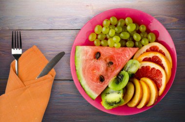 meyve bir ahşap arka plan üzerine dilimlenmiş. meyve bir tabağa dilimlenmiş