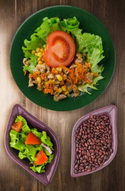 tavuk mideleri havuç ve Mısır ve bir tabak salataya salata. ahşap arka plan üzerinde Sebzeli tavuk salatası