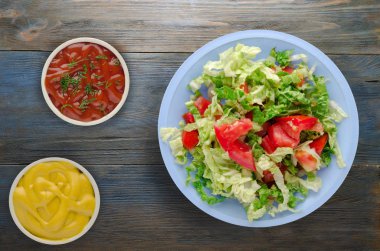 Vejetaryen Gıda. ahşap arka plan üzerinde bir tabakta lahana domates salatası. sağlıklı gıda