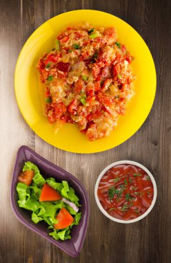 Haşlanmış domates soğan bir plaka üzerinde bir ahşap arka plan ile. haşlanmış domates soğan en iyi manzaralı. Vejetaryen Gıda