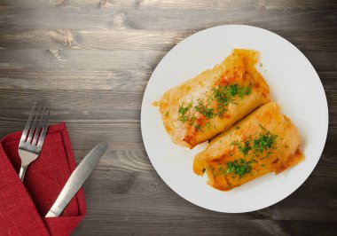 lahana bir tabak içinde alır. lahana bir ahşap arka plan üzerinde rulo. et lahana Üstten Görünüm.