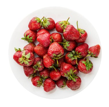 Çilek beyaz arka plan üzerinde izole bir plaka üzerinde. çilek plaka üstten görünüm üzerinde. sağlıklı gıda