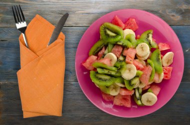 sağlıklı taze meyve salatası ahşap zemin üzerine tabak .
