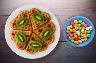 gofret kivi ve kızılcık ahşap arka plan üzerinde. Waffle plaka üstten görünüm üzerinde