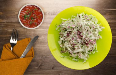 salata daikon, soğan ve bir ahşap zemin üzerine dereotu. bir tabak salata