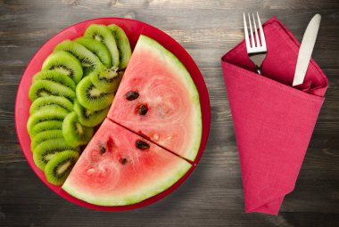 karpuz ve bir tabak ya da ahşap bir arka plan üzerinde dilimlenmiş kivi