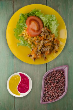 tavuk mideleri havuç ve Mısır ve bir tabak salataya salata. ahşap arka plan üzerinde Sebzeli tavuk salatası