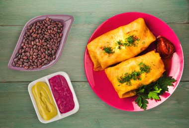 lahana bir tabak içinde alır. lahana bir ahşap arka plan üzerinde rulo. et lahana Üstten Görünüm.