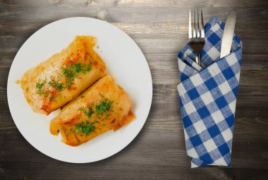 lahana bir tabak içinde alır. lahana bir ahşap arka plan üzerinde rulo. et lahana Üstten Görünüm.