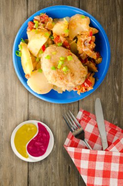 Patates ve haşlanmış domates ile Beşamel sos. ahşap arka plan üzerinde bir tabakta pirzola