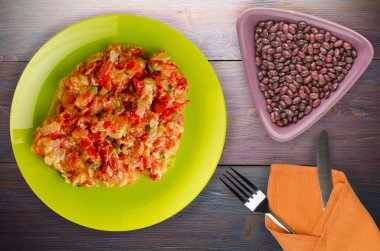 Haşlanmış domates soğan bir plaka üzerinde bir ahşap arka plan ile. haşlanmış domates soğan en iyi manzaralı. Vejetaryen Gıda