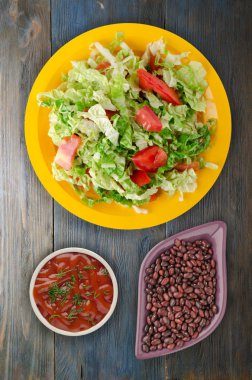 Vejetaryen Gıda. ahşap arka plan üzerinde bir tabakta lahana domates salatası. sağlıklı gıda