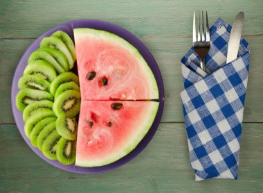 karpuz ve bir tabak ya da ahşap bir arka plan üzerinde dilimlenmiş kivi