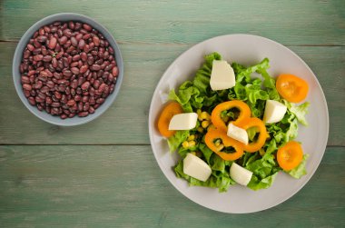  salata, peynir, salata, Mısır, biber ahşap arka plan üzerinde. Vejetaryen salata bir plaka üzerinde. Vejetaryen salata Üstten Görünüm