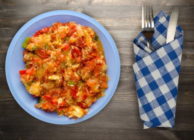 Haşlanmış domates soğan bir plaka üzerinde bir ahşap arka plan ile. haşlanmış domates soğan en iyi manzaralı. Vejetaryen Gıda