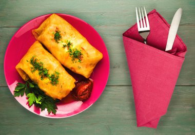 lahana bir tabak içinde alır. lahana bir ahşap arka plan üzerinde rulo. et lahana Üstten Görünüm.