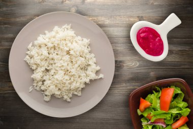 beyaz pirinç bir plaka üzerinde. ahşap arka plan üstten görünüm üzerinde pirinç. Asya sağlıklı gıda