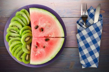 karpuz ve bir tabak ya da ahşap bir arka plan üzerinde dilimlenmiş kivi
