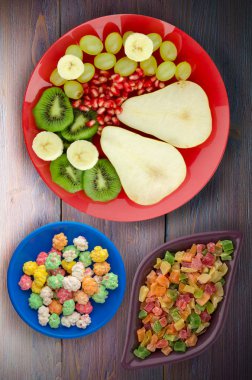 ahşap arka plan üzerinde meyve karışımı (armut, kivi, üzüm, muz, nar). meyve bir plaka üzerinde